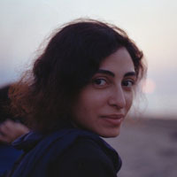 An Iranian woman at the beach looks to the side at the camera