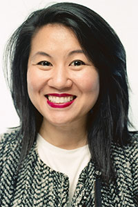 Thahn wears red lipstick and has long, straight, black hair.