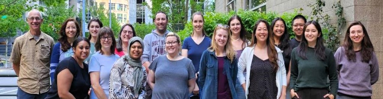 Over a dozen members of the VST Volunteer graduating class of 2023 pose for a photo, including men and women of all ages, races, and ethnic backgrounds