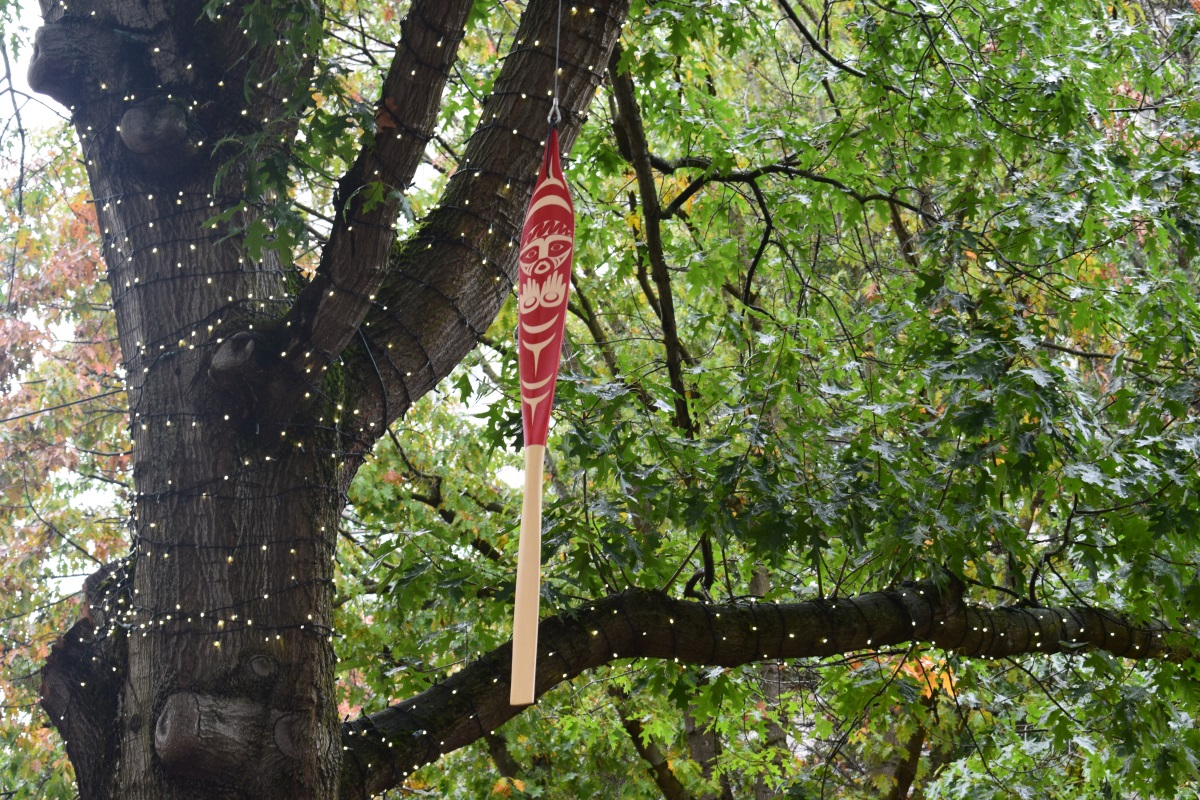 Prayer Paddle hanging in a tree in a park