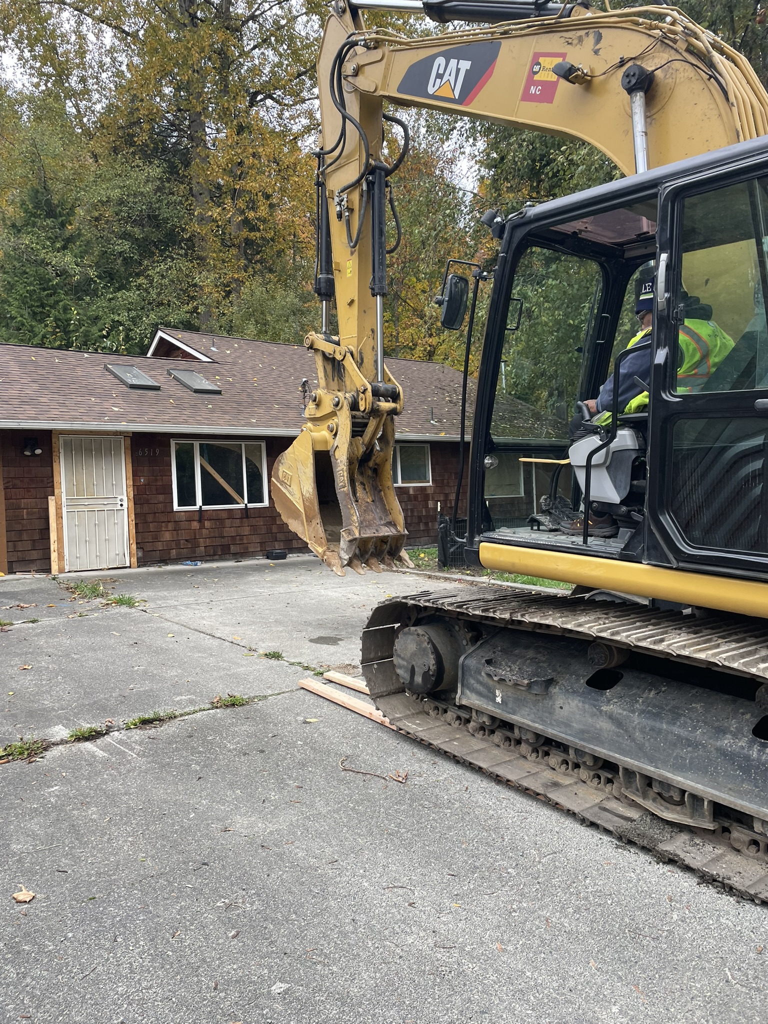 A Seattle Conservation Corps member drives a Caterpillar to begin demolition