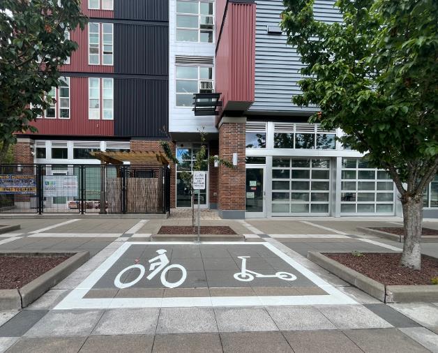 Example of a bike and scooter parking zone - on the sidewalk there is a large box with an icon of a bike and scooter inside.