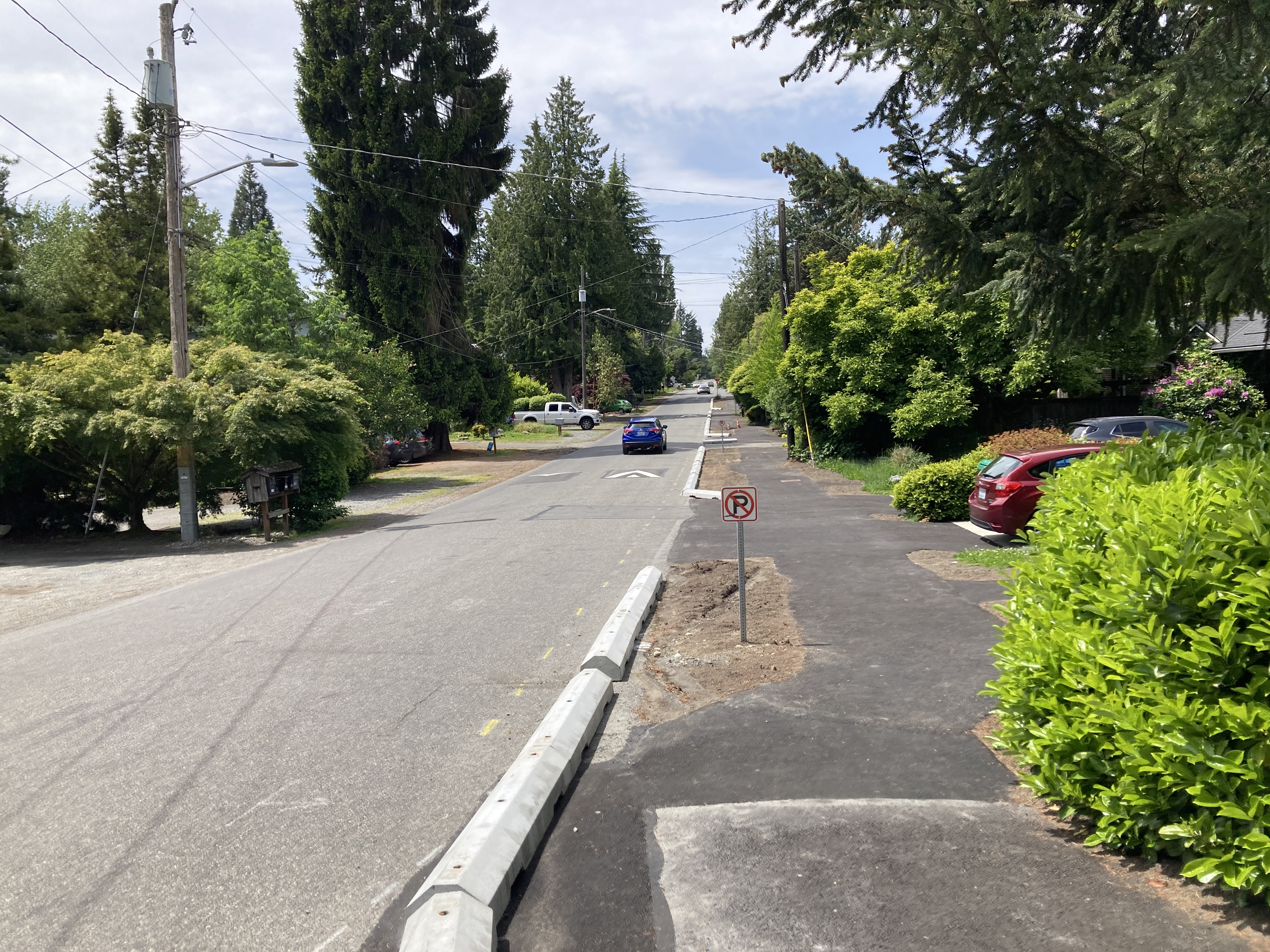 The photo above shows the newly asphalt walkway along N 122nd St between Corliss Ave N and 1st Ave NE , with updated signage and planting strip in progress
