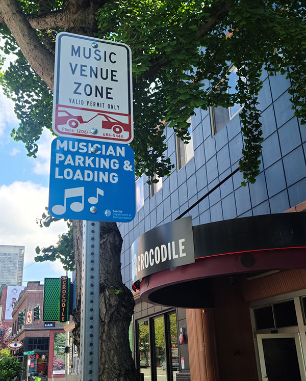 A sign next to the Crocodile venue that says "Music Venue Zone - Musician Parking and Loading"