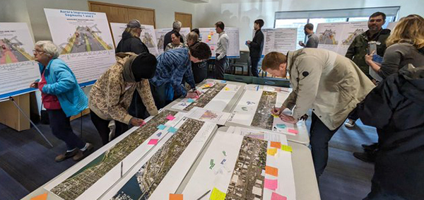People looking at concept designs for Aurora at a community meeting