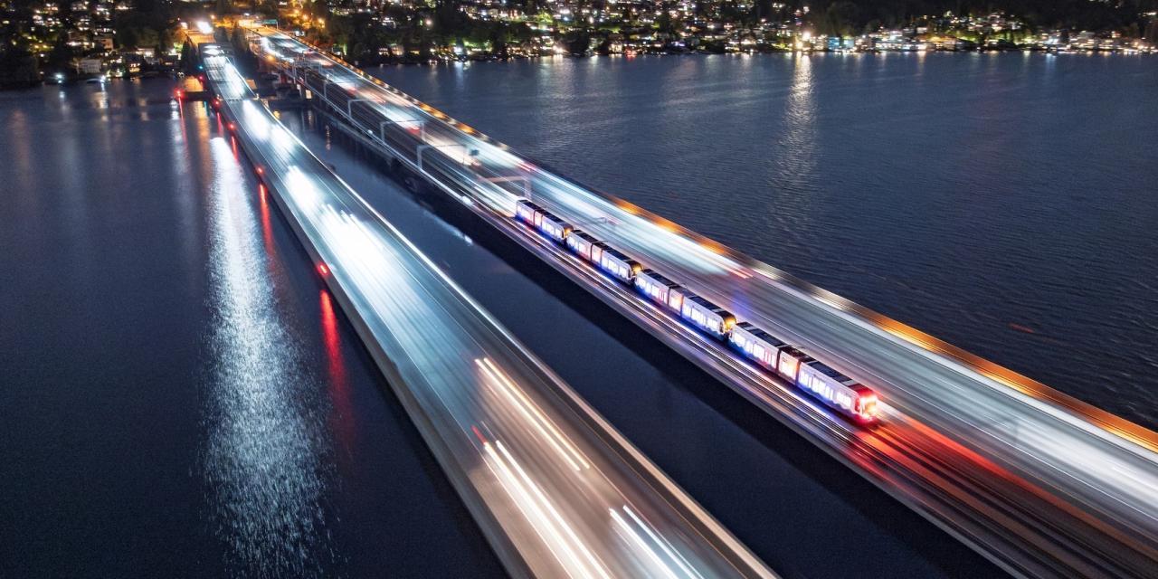 Ariel view of light rail crossing the I-90 bridge over Lake Washington at night