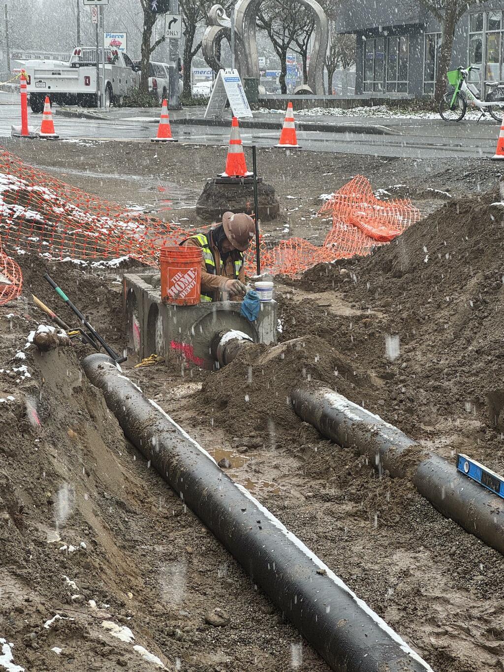 A worker connected the storm drain line to a catch basin during a rare Seattle snowy day.