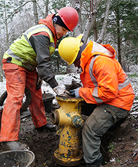 Photo of two people working on a hydrant
