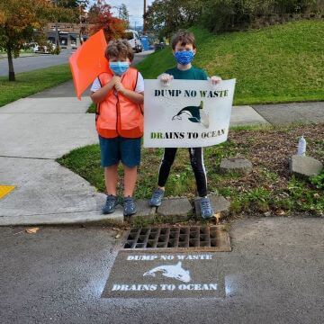Two children standing on curb.
