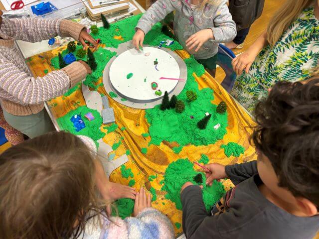 Children working with tabletop model of park.