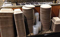 Stacks of approved food service takeout containers at a restaurant.