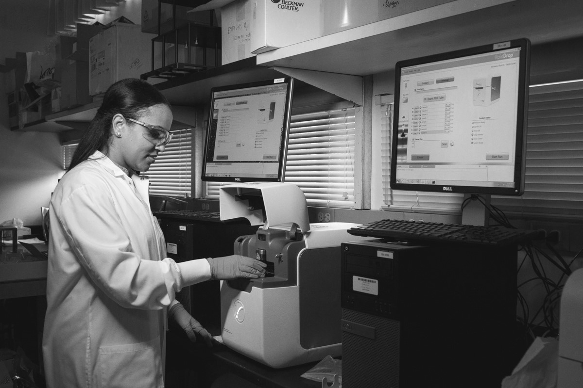 Woman wearing lab coat and working in a lab.