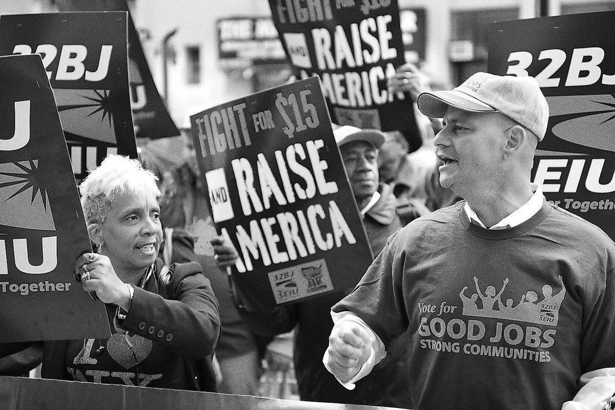 Workers holding picket signs at an outdoor rally