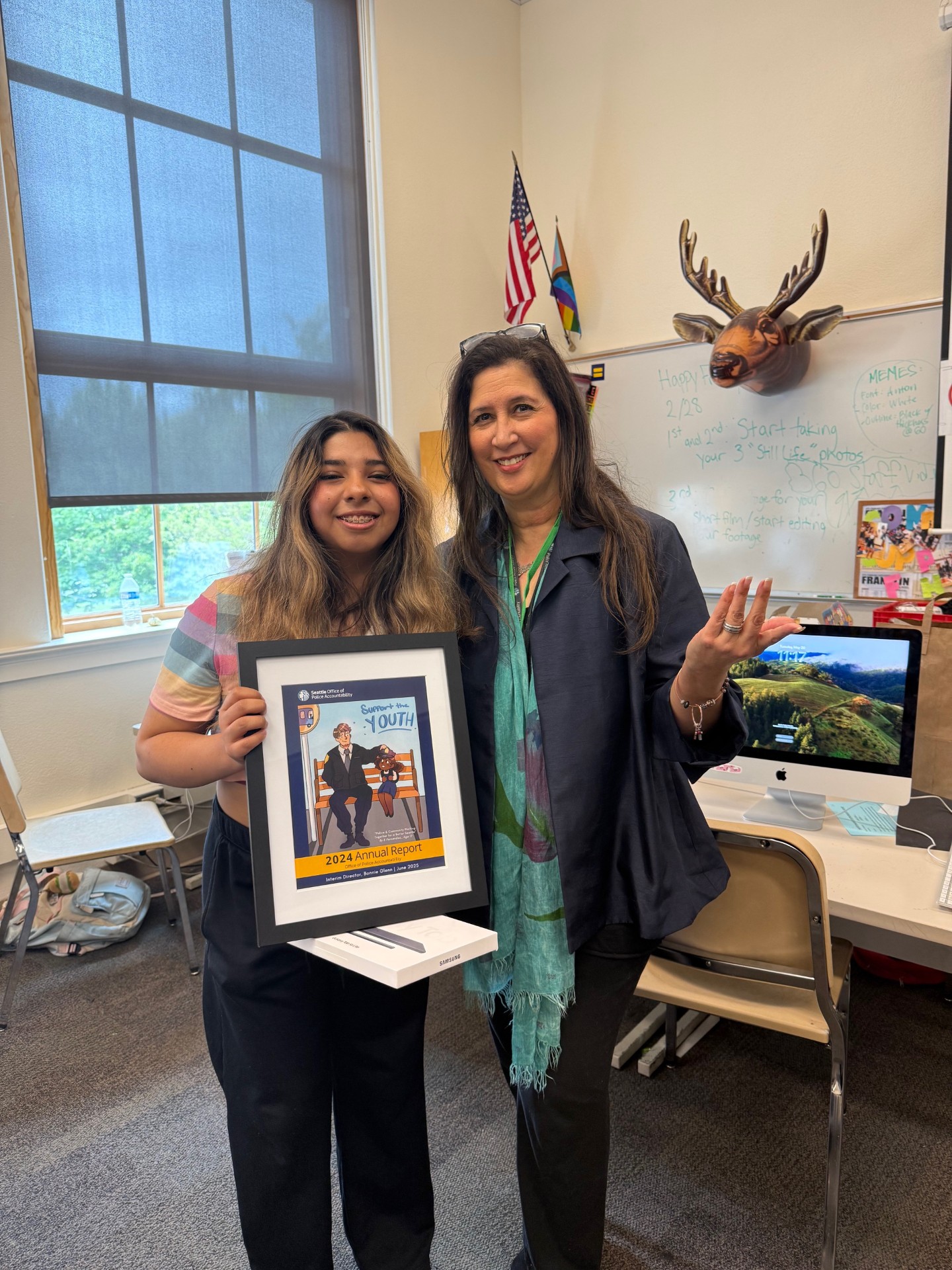 Art Contest Winner, E.Fernandez with OPA Interim Director, Bonnie Glenn, holding their winning cover design