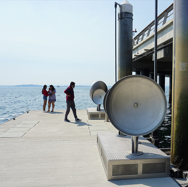 Rendering of people standing on a floating dock looking at the art installation Land Buoy Bells
