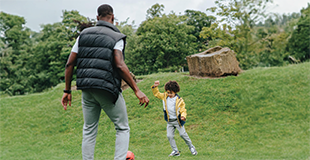 a family playing with a red ball in a public park