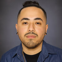 Daniel has light scruff and pierced ears.