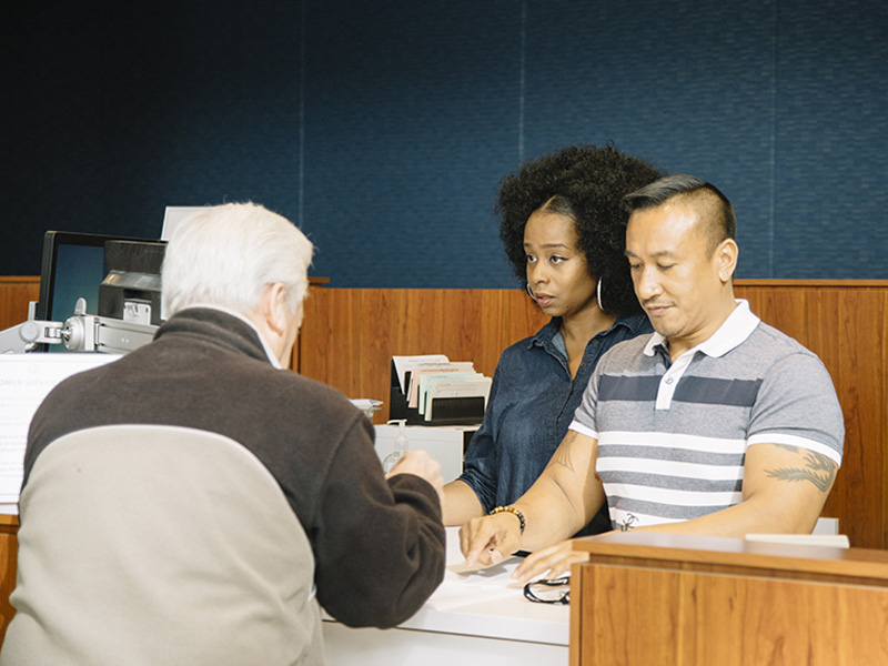 Staff members helping an elderly customer at the Downtown Customer Service Center