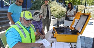 A HUB volunteer sits at a table during a community disaster training drill