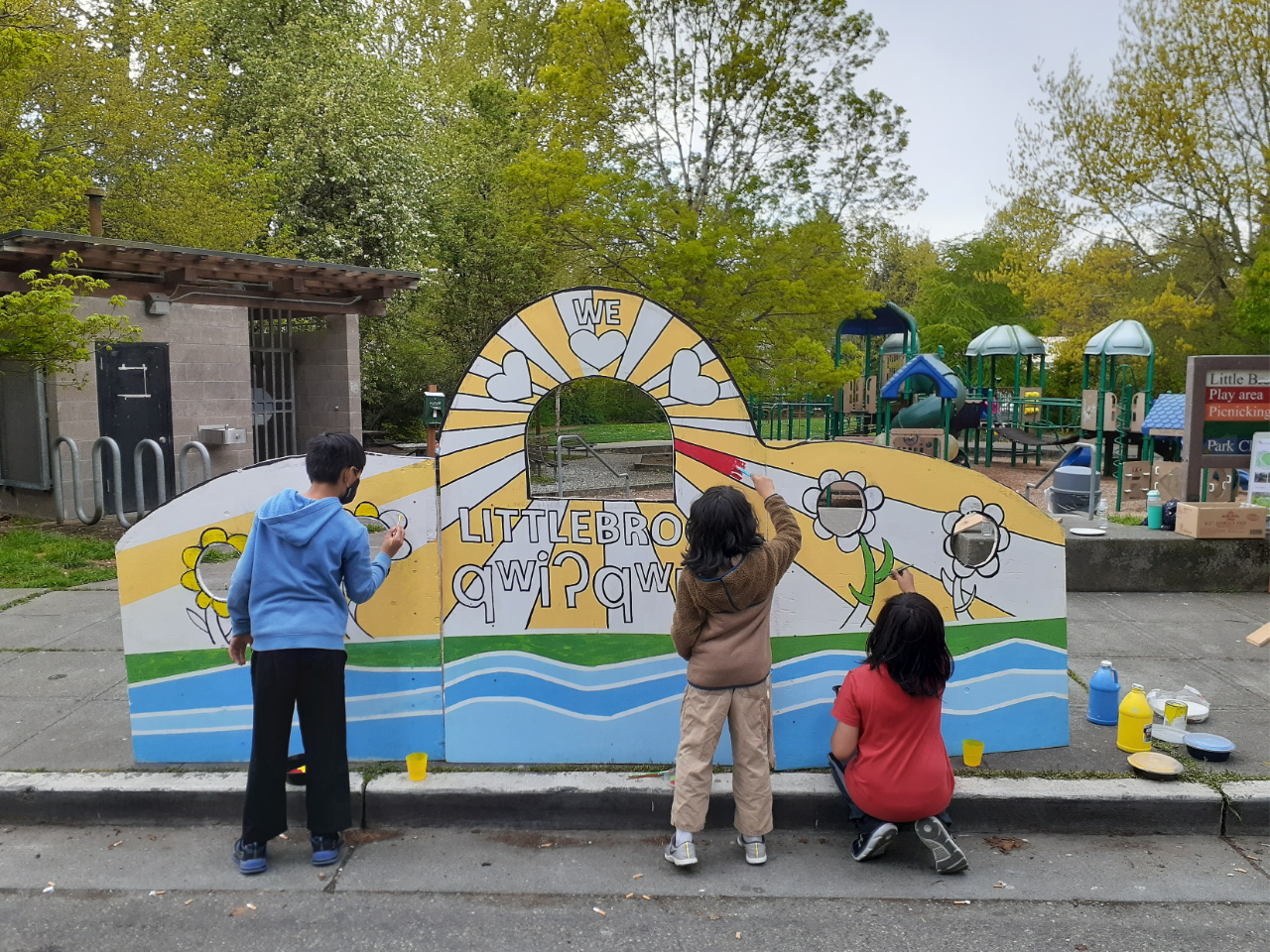 Children painintg a mural in a city park