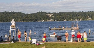 Crowd of people swimming at Matthews Beach Park.  Lifeguard tower in the foreground.