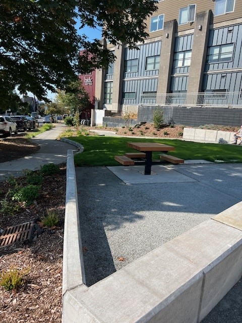 Picnic table and lawn in a landscaped neighborhood park with shade trees