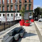 Portal Porch featuring bright red oversized planters and benches that look like stacked bars.