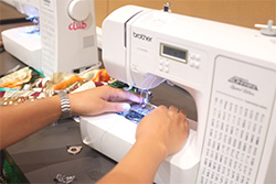 Person using a sewing machine at a workshop.