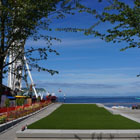A view of the elevated lawn from the tree grove with Elliott Bay in the background.